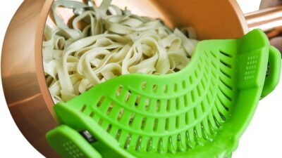 AUOON green silicone clip-on strainer draining pasta from a pot
