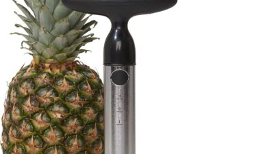 OXO Good Grips stainless steel pineapple corer and slicer standing next to a whole pineapple