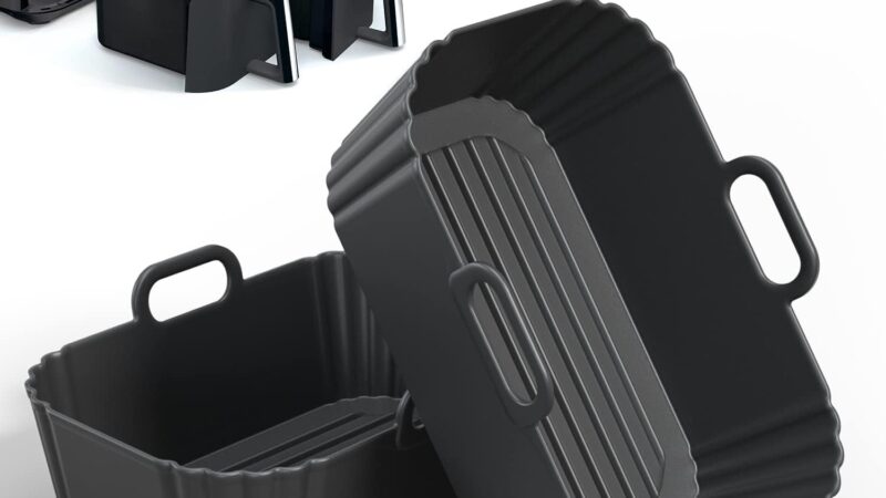 Two black PINTAUR silicone air fryer liners with handles, shown beside a Ninja dual basket air fryer